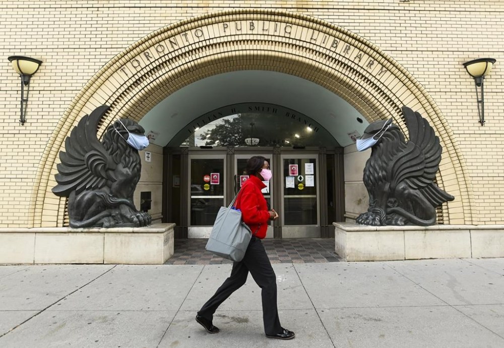 The Toronto Public Library says many of its most-borrowed books for 2024 centre strong female characters. A woman walks past a Toronto Public Library in Toronto on Friday, October 2, 2020. THE CANADIAN PRESS/Nathan Denette