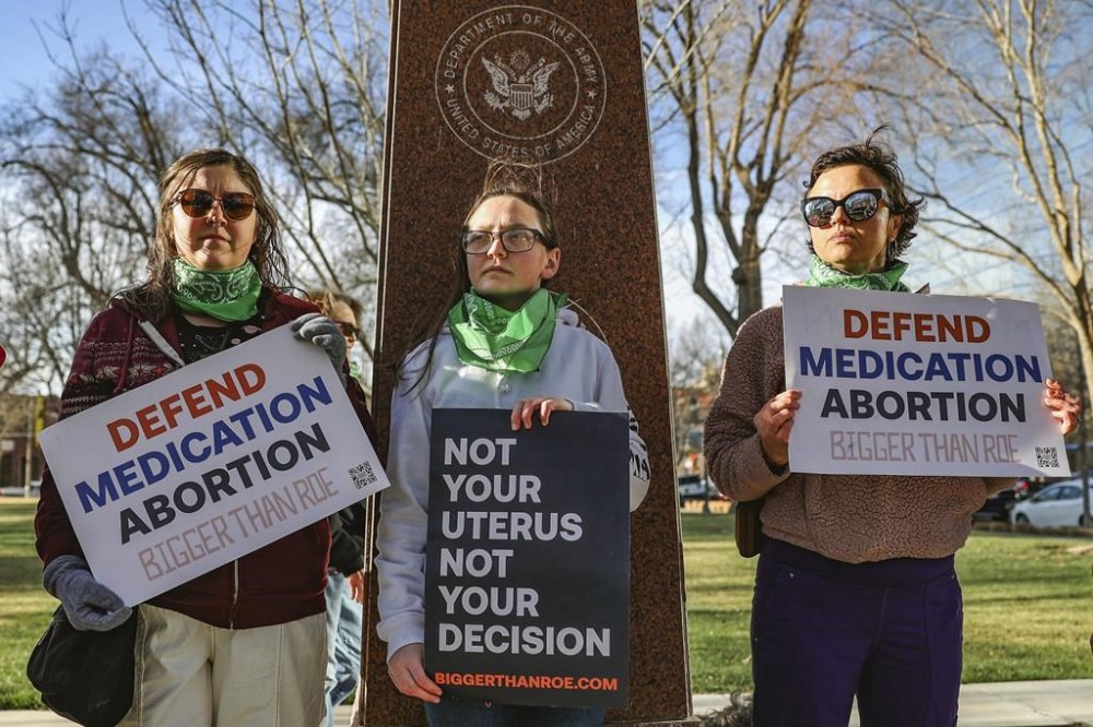 FILE - Three members of the Women's March group protest in support of access to abortion medication outside the Federal Courthouse on Wednesday, March 15, 2023 in Amarillo, Texas. (AP Photo/David Erickson, File)