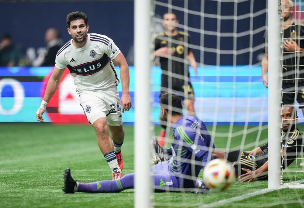 Vancouver Whitecaps' Brian White, back left, scores against Los Angeles FC goalkeeper Hugo Lloris as Eddie Segura, back lower right, watches during the second half of a first-round MLS Cup playoffs soccer match, in Vancouver, on Sunday, November 3, 2024. THE CANADIAN PRESS/Darryl Dyck