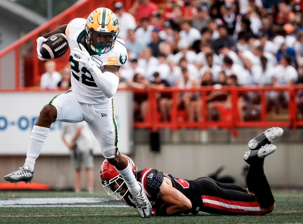 Edmonton Elks' Javon Leake (22) escapes a tackle by Calgary Stampeders' Ben Labrosse (29) during first half CFL football action in Calgary, Monday, Sept. 2, 2024.THE CANADIAN PRESS/Jeff McIntosh