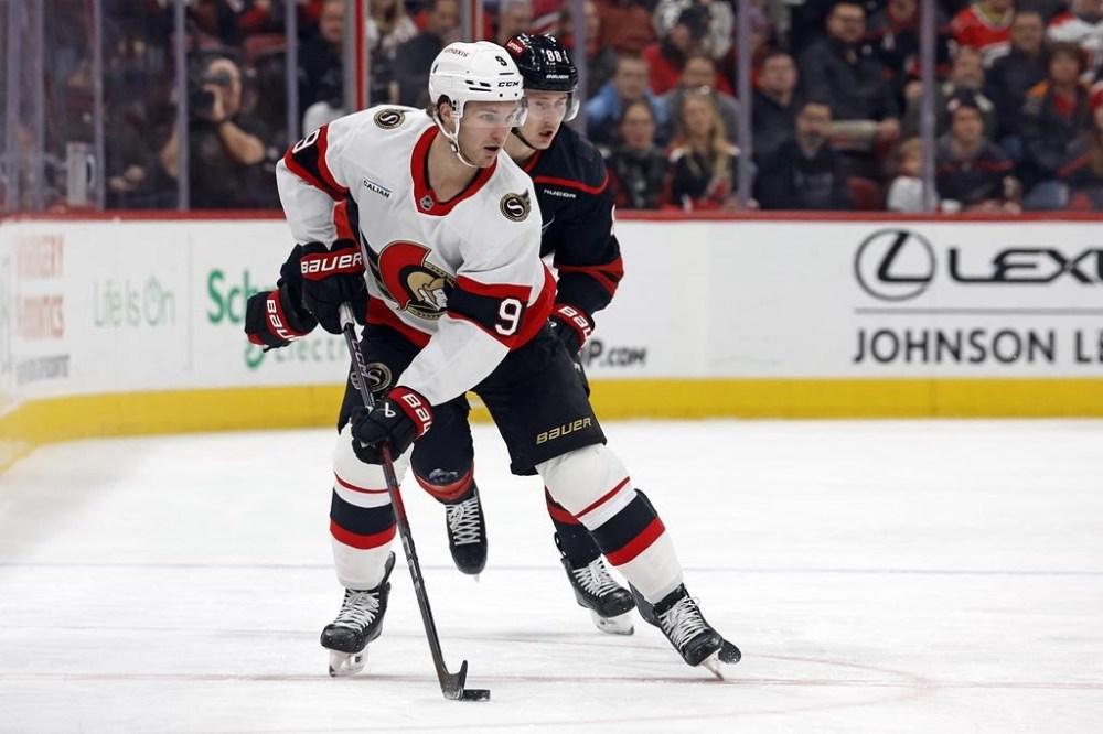 Ottawa Senators' Josh Norris (9) protects the puck in front of Carolina Hurricanes' Martin Necas (88) during the first period of an NHL hockey game in Raleigh, N.C., Friday, Dec. 13, 2024. (AP Photo/Karl B DeBlaker)