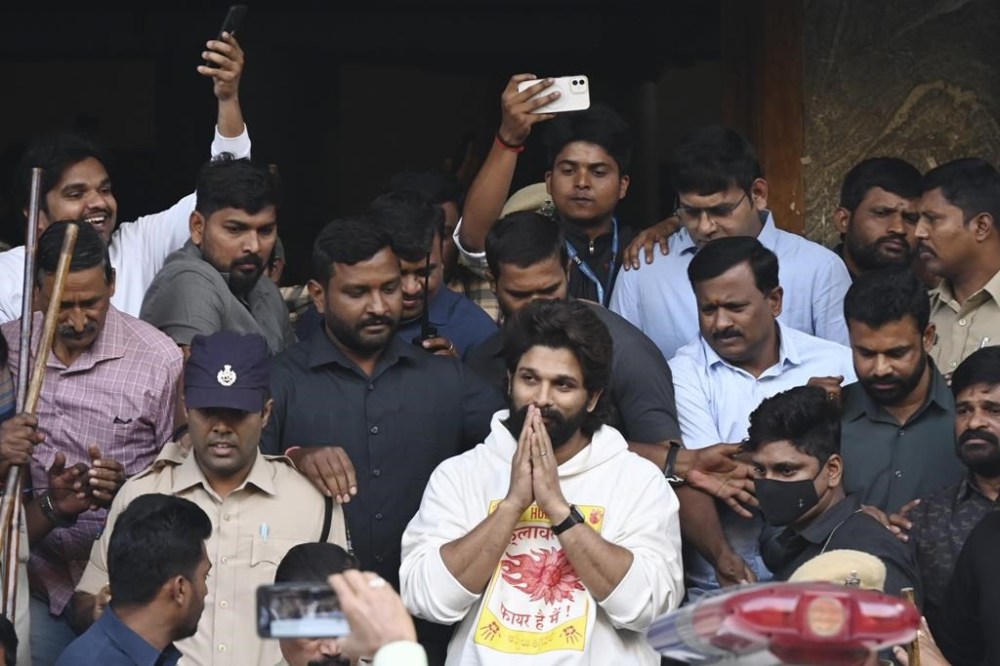 Indian Southern film actor Allu Arjun, center, greets his fans in Hyderabad, India, Friday, Dec. 13, 2024, as he leaves a hospital where he was taken for medical checkup by policemen before arresting him after his appearance at a film screening allegedly led to a crush of fans in which a woman died. (AP Photo)