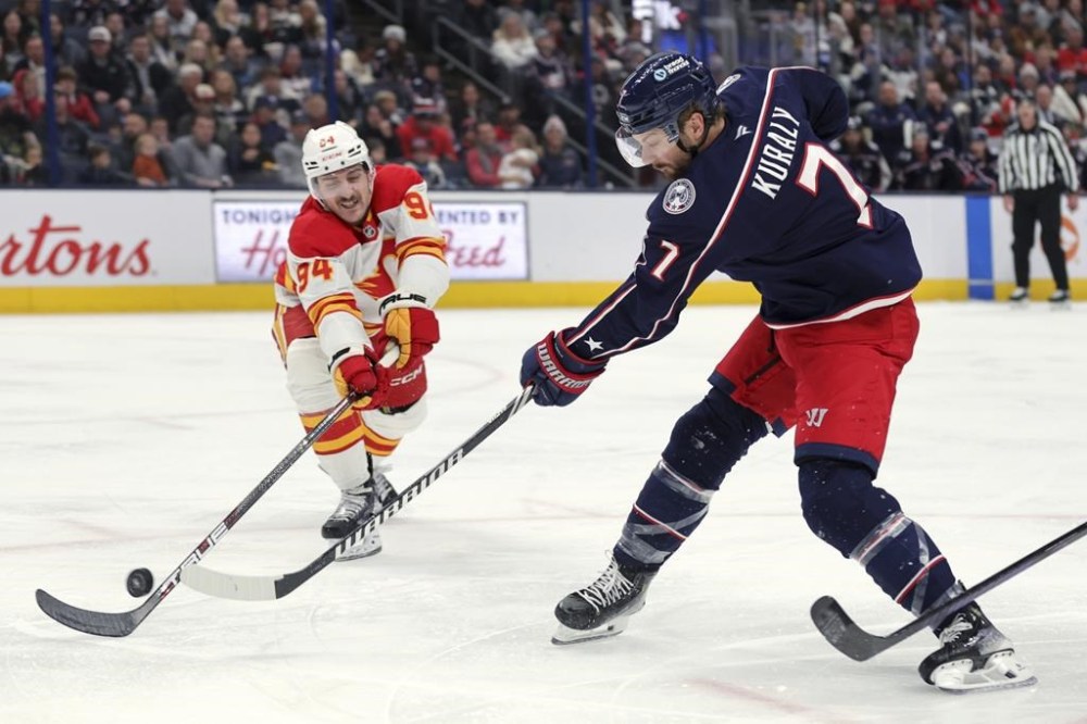 Columbus Blue Jackets forward Sean Kuraly, right, shoots the puck in front of Calgary Flames defenceman Brayden Pachal during an NHL hockey game in Columbus, Ohio, Friday, Nov. 29, 2024. The Flames have signed Pachal to a two-year contract extension with an average annual value of US$1,187,500, the NHL club announced Tuesday. THE CANADIAN PRESS/AP/Paul Vernon