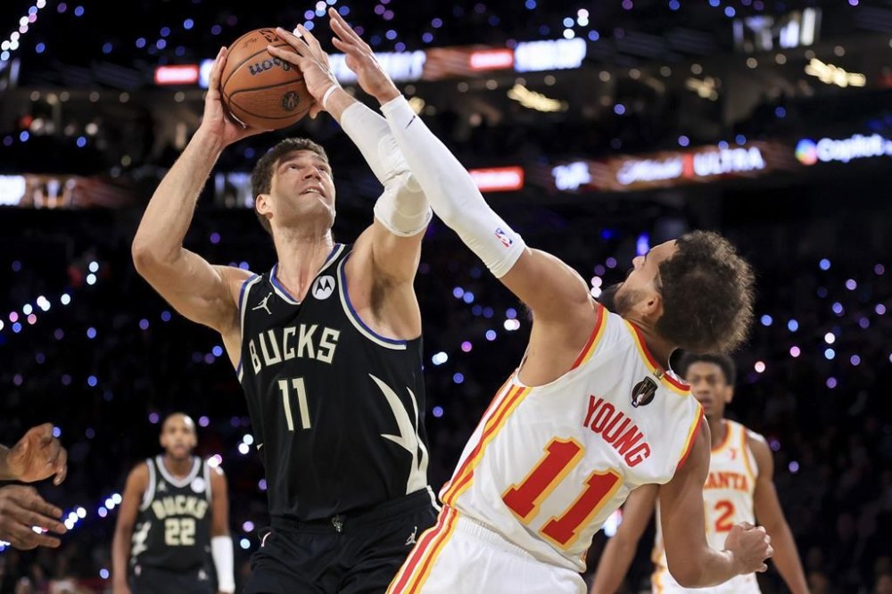 Milwaukee Bucks center Brook Lopez, front left, looks to shoot against Atlanta Hawks guard Trae Young, front right, during the second half of a semifinal game in the NBA Cup basketball tournament Saturday, Dec. 14, 2024, in Las Vegas. (AP Photo/Ian Maule)