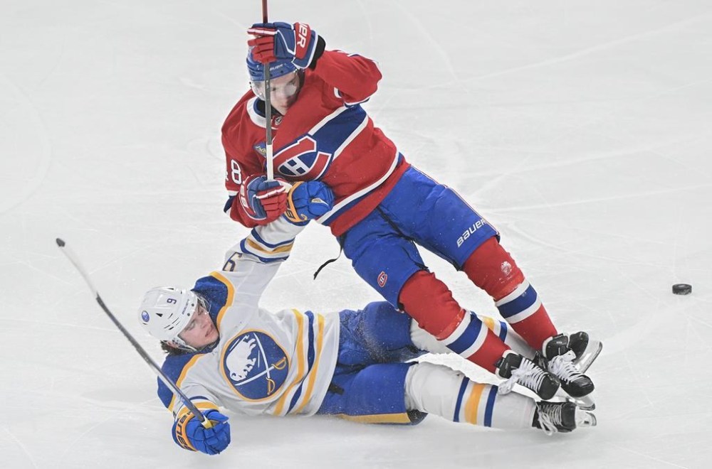 Montreal Canadiens' Lane Hutson (48) is tripped by Buffalo Sabres' Zach Benson (9) during first period NHL hockey action in Montreal, Tuesday, Dec. 17, 2024. THE CANADIAN PRESS/Graham
