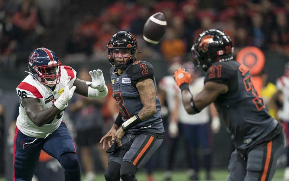 B.C. Lions quarterback Vernon Adams Jr. (middle) throws a pass to William Stanback (right) while pressured by Montreal Alouettes Lwal Uguak during the first half of CFL football action in Vancouver, B.C., Saturday, Oct. 19, 2024. THE CANADIAN PRESS/Rich Lam
