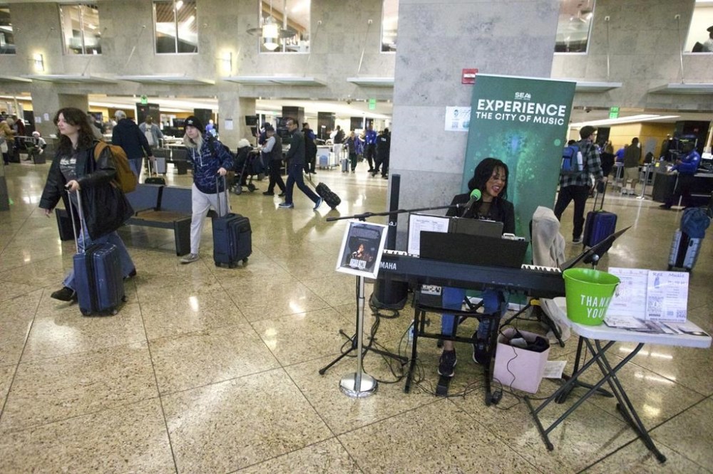 Roz McCommon performs amid travelers at Seattle-Tacoma International Airport on November 26, 2024, in SeaTac, Wash. (AP Photo/Manual Valdes)