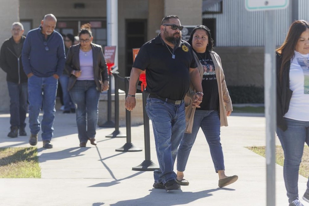 Javier and Gloria Cazares, center, the parents of Jacklyn Cazares who was killed in the May 2022 Robb Elementary mass shooting along with 18 other children and two teachers, walk out of the Uvalde County Justice Center after attending a pretrial hearing for two officers, Thursday morning, Dec. 19, 2024, in Uvalde, Texas. (Sam Owens/The San Antonio Express-News via AP)