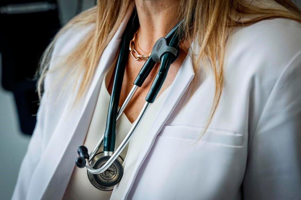 A doctor wears a lab coat and stethoscope in an exam room at a health clinic in Calgary on Friday, July 14, 2023. THE CANADIAN PRESS/Jeff McIntosh