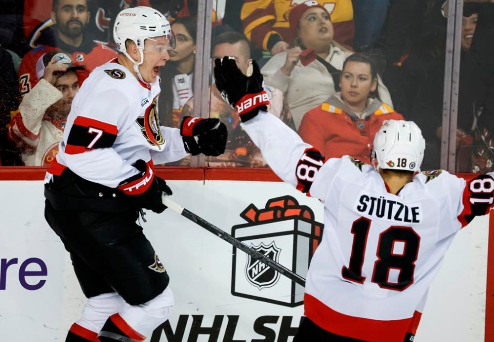 Ottawa Senators' Brady Tkachuk, left, celebrates his game-winning goal with teammate Tim Stutzle during overtime NHL hockey action against the Calgary Flames in Calgary on Thursday, Dec. 19, 2024.THE CANADIAN PRESS/Jeff McIntosh