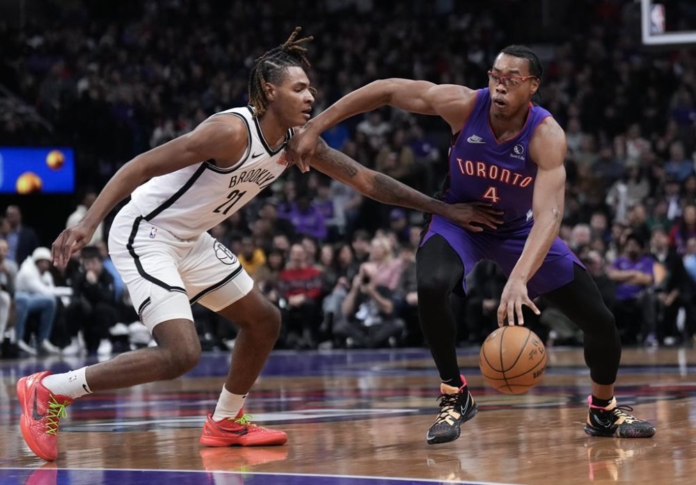 Toronto Raptors forward Scottie Barnes (4) tries to drive past Brooklyn Nets forward Noah Clowney (21) during first half NBA basketball action in Toronto on Thursday, December 19, 2024. THE CANADIAN PRESS/Nathan Denette