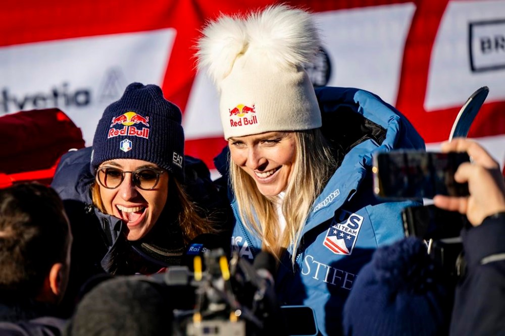 Sofia Goggia of Italy, left, and Lindsey Vonn of United States of America, talk with journalists after completing an alpine ski, women's World Cup super G, in St. Moritz, Switzerland, Saturday, Dec. 21, 2024. (Jean-Christophe Bott/Keystone via AP)