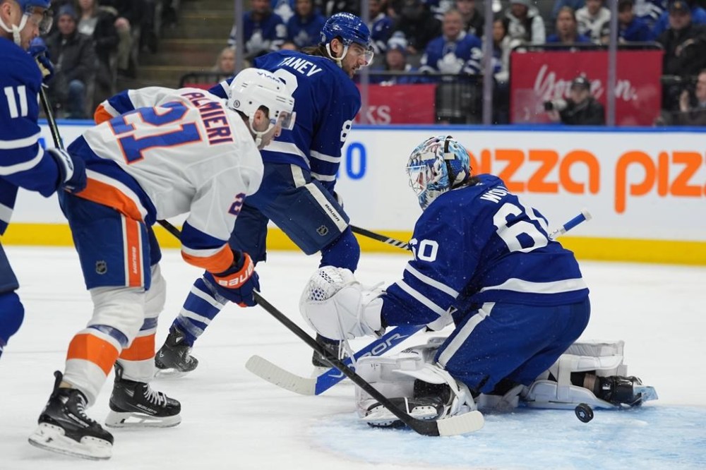 New York Islanders centre Kyle Palmieri (21) looks on as teammate Isaiah George, not shown, scores on Toronto Maple Leafs goaltender Joseph Woll (60) during third period NHL action in Toronto on Saturday, Dec. 21, 2024. THE CANADIAN PRESS/Frank Gunn