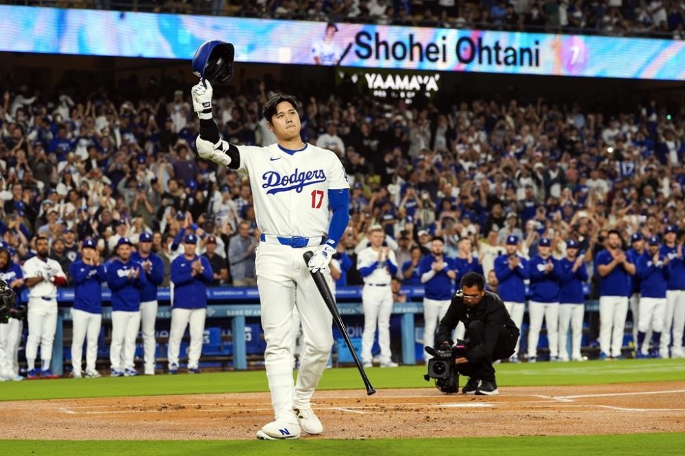 FILE - Los Angeles Dodgers designated hitter Shohei Ohtani (17) is honored for being first MLB player to achieve 50 home runs and 50 stolen bases in a single season during the first inning of a baseball game against the Colorado Rockies in Los Angeles, Friday, Sept. 20, 2024. (AP Photo/Ashley Landis, File)