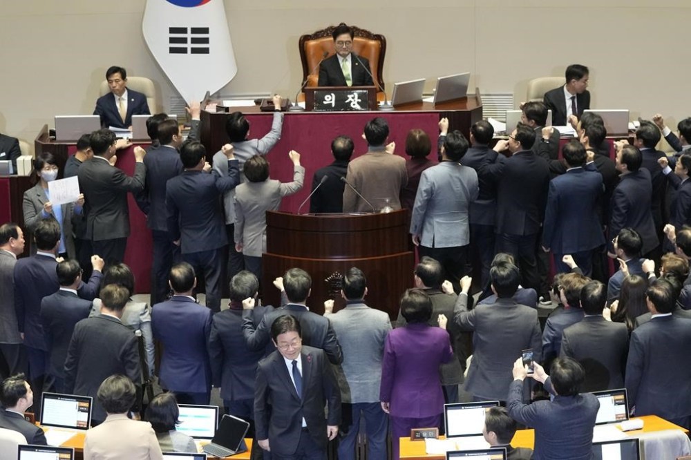 South Korea's opposition Democratic Party leader Lee Jae-myung, bottom center, walks past lawmakers of the ruling People Power Party protesting to South Korea's National Assembly Speaker Woo Won Shik, top center, during a plenary session for the impeachment motion against South Korean acting President Han Duck-soo at the National Assembly in Seoul, South Korea, Friday Dec. 27, 2024. (AP Photo/Ahn Young-joon)