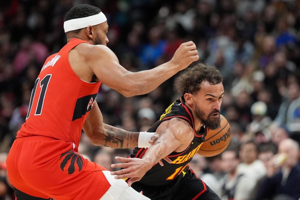 Atlanta Hawks guard Trae Young (11) drives to the net under pressure from Toronto Raptors forward Bruce Brown (11) during second half NBA basketball action in Toronto, Sunday, Dec. 29, 2024. THE CANADIAN PRESS/Frank Gunn