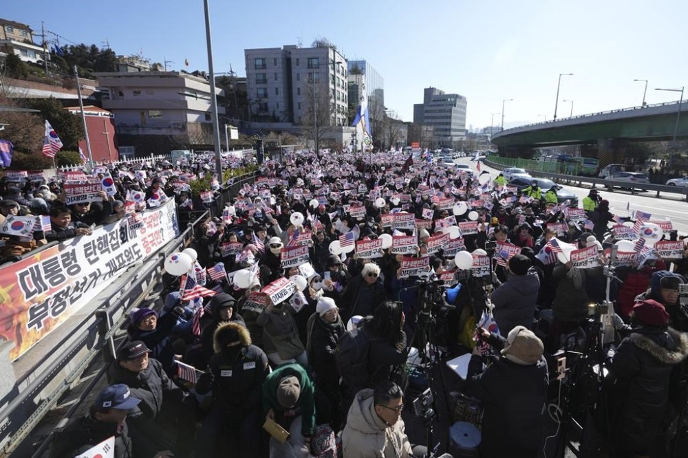 Supporters of impeached South Korean President Yoon Suk Yeol stage a rally near the presidential residence in Seoul, South Korea, Tuesday, Dec. 31, 2024. The letters read