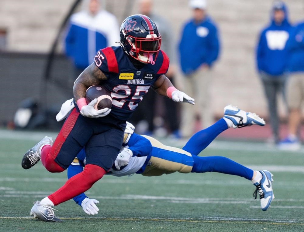 Montreal Alouettes running back Walter Fletcher (25) evades a tackle by Winnipeg Blue Bombers defensive back Jake Kelly (16) during CFL football action in Montreal on Saturday, Oct. 26, 2024.The Alouettes have signed Fletcher to a two-year contract extension, the CFL club announced Tuesday.THE CANADIAN PRESS/Christinne Muschi