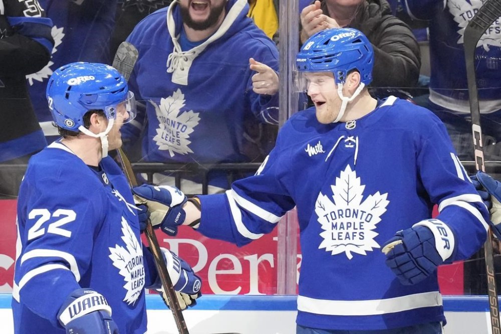 Toronto Maple Leafs centre Steven Lorentz (18) celebrates with teammate Jake McCabe (22) after scoring his team's second goal against New York Islanders during second period NHL hockey action in Toronto on Tuesday, December 31, 2024.THE CANADIAN PRESS/Chris Young