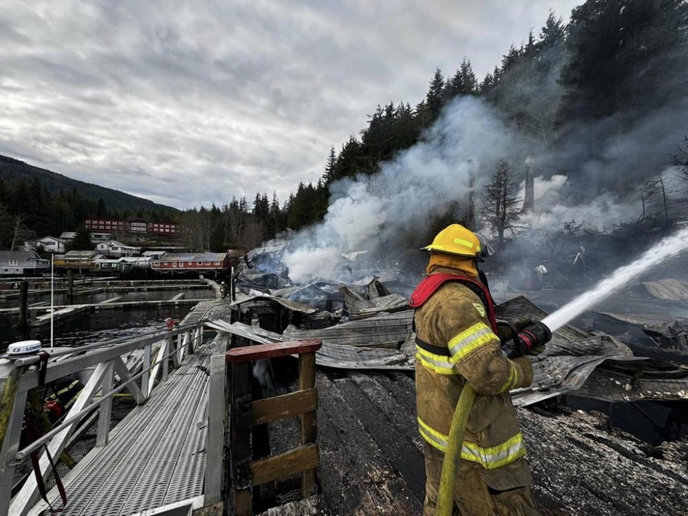 An Alert Bay Fire Department firefighter trains his hose on a blaze at the Telegraph Cove boardwalk on northern Vancouver Island on the morning of Tuesday, Dec. 31, 2024. THE CANADIAN PRESS/HO-Alert Bay Fire Department*MANDATORY CREDIT *
