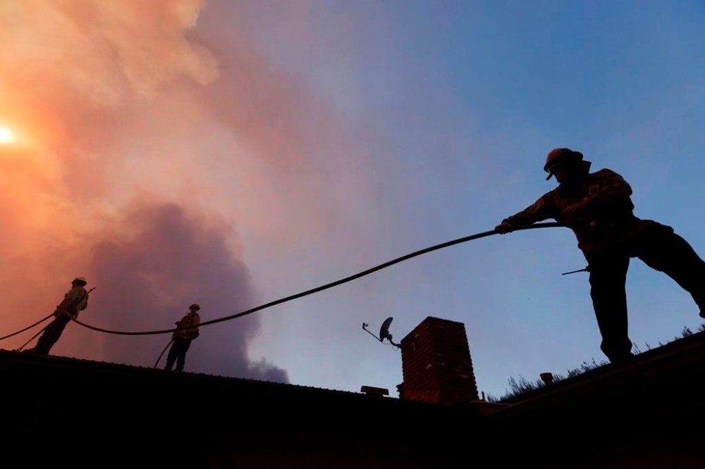 Firefighters prepare for structure protection as the Palisades Fire advances in the Pacific Palisades neighborhood of Los Angeles, Tuesday, Jan. 7, 2025. (AP Photo/Ethan Swope)