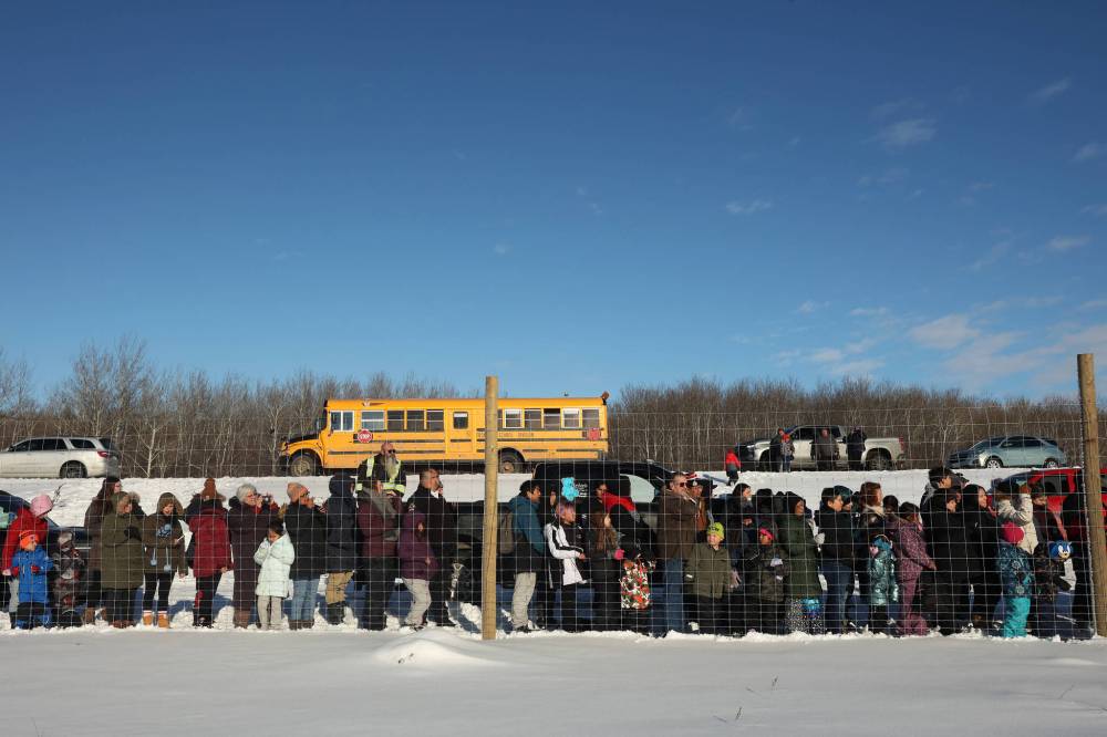 Community members crowd around the bison enclosure at Birdtail Sioux First Nation to watch as the bison are released on Tuesday. (Tim Smith/The Brandon Sun)