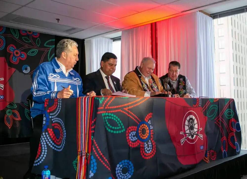 Manitoba Métis Federation (MMF) President David Chartrand (second from right) signs a copy of the Red River Métis Self Government Treaty at the MMF building in Winnipeg on Nov. 30. Also seen here, (from left) Minster of Northern Affairs Dan Vandal, Federal Minister of Crown-Indigenous Relations Gary Anandasangaree and lead negotiator for the Red River Métis, Allan Benoit. Two Manitoba Dakota First Nations have filed a court injunction that seeks to have the recently signed treaty declared invalid. (Winnipeg Free Press)