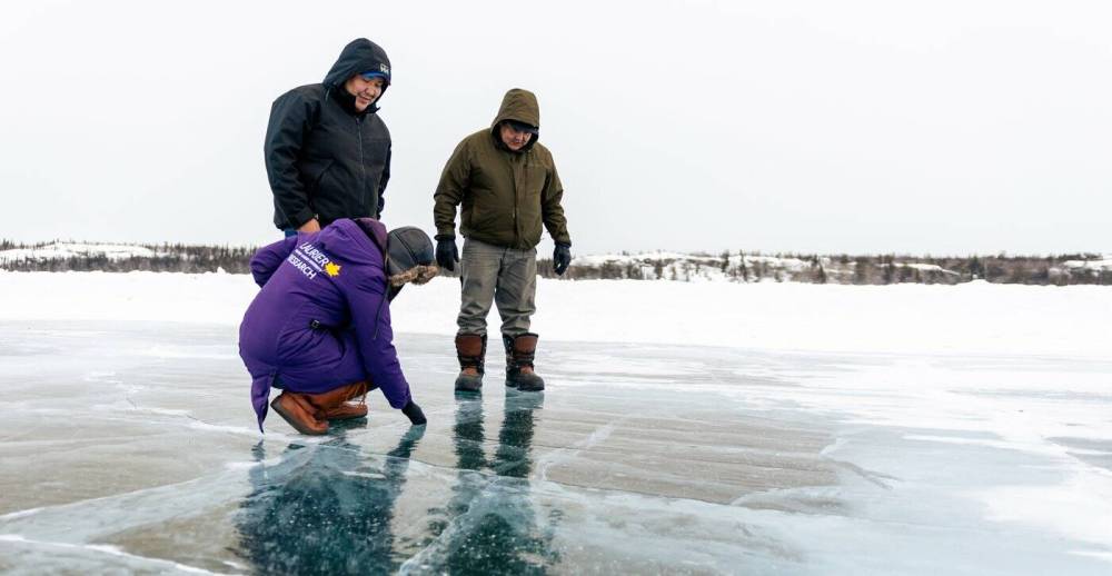 Wilfrid Laurier University researcher Homa Kheyrollah Pour examines an ice road with Chase Lockhart, centre, and Rubin Fatt, right, Indigenous guardians from Łutsel Kʼé, N.W.T., in an undated handout photo. (The Canadian Press)