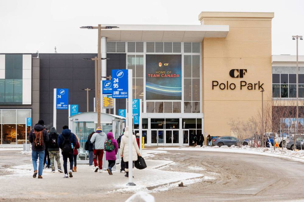 People stand at a bus stop outside Winnipeg’s Polo Park mall last month. The mall was the site of a random, unprovoked stabbing last week. (Mike Deal/Winnipeg Free Press)