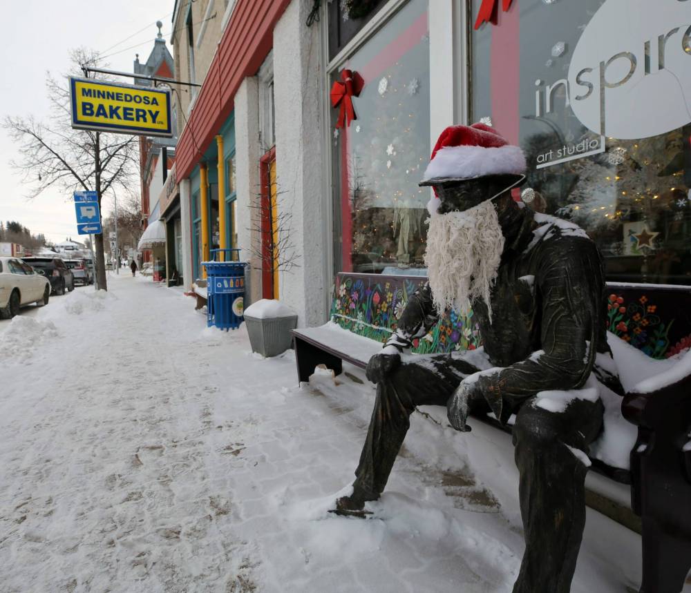 Art Van Winkel — the stationary fixture outside a Minnedosa art store — got his head back in the right place this Christmas season. Art lost his head (literally!) to thieves several times this year. As part of the latest attempt to capitate him, Art now has a camera pointed at his head for surveilling any mischief makers, as well as an air tag installed within. He is seen here on Tuesday afternoon, at his usual perch in front of the Inspire Art Studio — all decked up for the holidays — wearing a Santa hat and a beard. (Connor McDowell/The Brandon Sun)