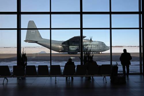 Travellers at the Brandon Municipal Airport look out on a Canadian Forces CC-130 Hercules aircraft on the tarmac during a military exercise at the airport in December 2024. (Tim Smith/The Brandon Sun files)