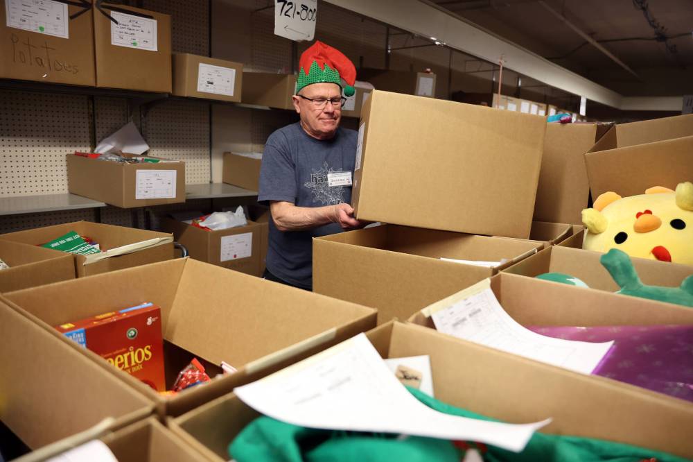 Duncan Waddell wears a festive elf hat while organizing and moving Christmas hampers at Brandon-Westman Christmas Cheer headquarters on Seventh Street on Wednesday. Volunteers worked all day and evening Wednesday to prep and send out Christmas hampers to families in need for the holidays. Volunteers will be back at it today to deliver the remainder of the hampers.
(Tim Smith/The Brandon Sun)