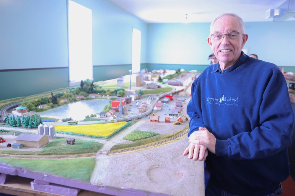 Brandon Hills Model Railway Club member Erich Stumme poses for a picture with the N-scale model train on Saturday. (Abiola Odutola/The Brandon Sun)