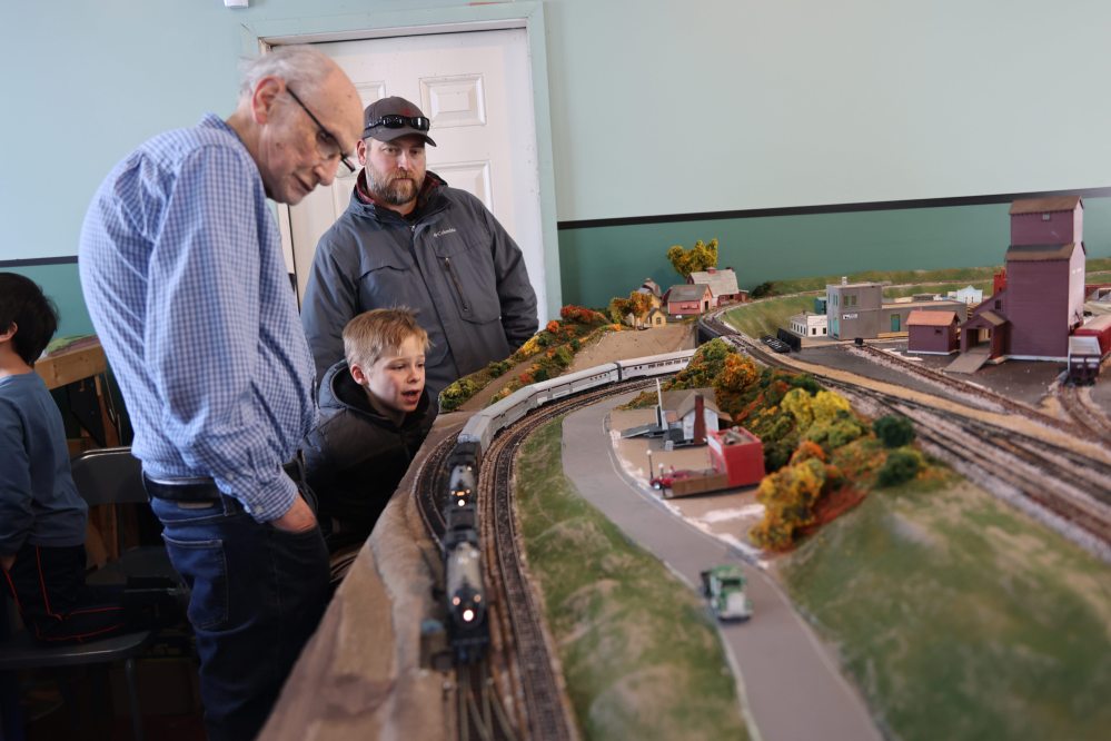James Smith, 7, (middle) shows excitement as trains move on the HO-scale model railway layout built by the Brandon Hills Model Railway Club in five years at the Commonwealth Air Training Plan Museum, Saturday afternoon while club member Bill McGuire (left) and Smith’s father, Chris, look on. (Abiola Odutola/The Brandon Sun)