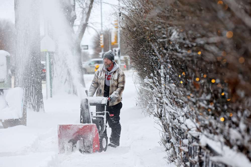 Shane Burgoyne uses a snowblower to clear the driveway of a neighbour along Victoria Avenue on Monday morning after heavy snowfall in Brandon on Sunday. (Tim Smith/The Brandon Sun)