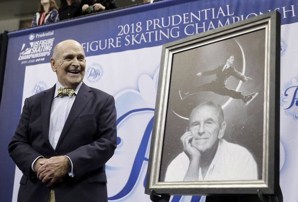 FILE - Dick Button smiles next to a painting of him while honored at the U.S. Figure Skating Championships in San Jose, Calif., Thursday, Jan. 4, 2018. (AP Photo/Marcio Jose Sanchez, File)