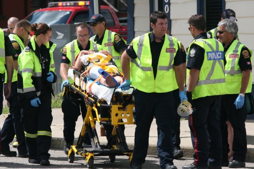Emergency crews are seen transporting an injured female pedestrian on a stretcher to a waiting ambulance. The provincial Progressive Conservatives have released data that reflects a shortage of paramedics in rural Manitoba, calling on the NDP to make good on their campaign promises to fix health care and offer incentives to paramedics willing to work in small communities. (File)