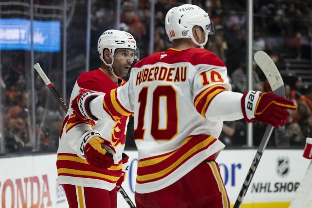 Calgary Flames center Nazem Kadri (91) celebrates his goal with center Jonathan Huberdeau (10) during the second period of an NHL hockey game against the Anaheim Ducks, Tuesday, Jan. 7, 2025, in Anaheim, Calif. (AP Photo/Kyusung Gong)