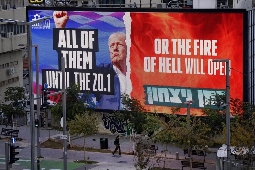 An electronic billboard beams an image of President-elect Donald Trump and references his threat to unleash hell if hostages held in Gaza are not freed until his inauguration later this month. in Tel Aviv, Israel, on Wednesday, Jan. 8, 2025. (AP Photo/Oded Balilty)