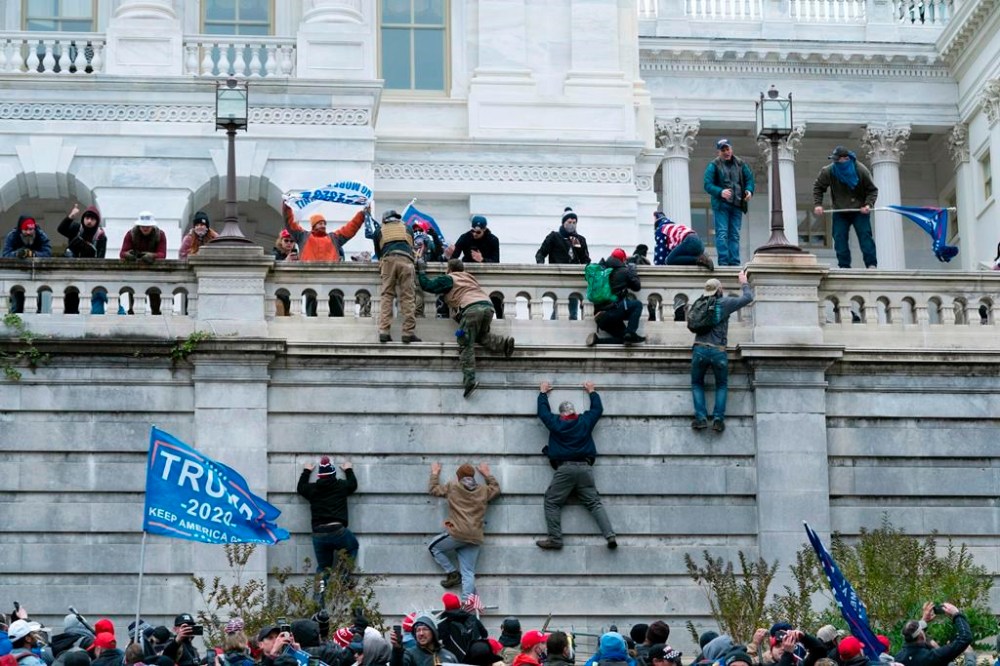An American rioter sentenced to nine months in jail south of the border after storming the U.S. Capitol on Jan. 6, 2021, has been arrested in British Columbia. In this Jan. 6, 2021, file photo, violent insurrectionists loyal to President Donald Trump scale the west wall of the U.S. Capitol in Washington. THE CANADIAN PRESS/AP-Jose Luis Magana