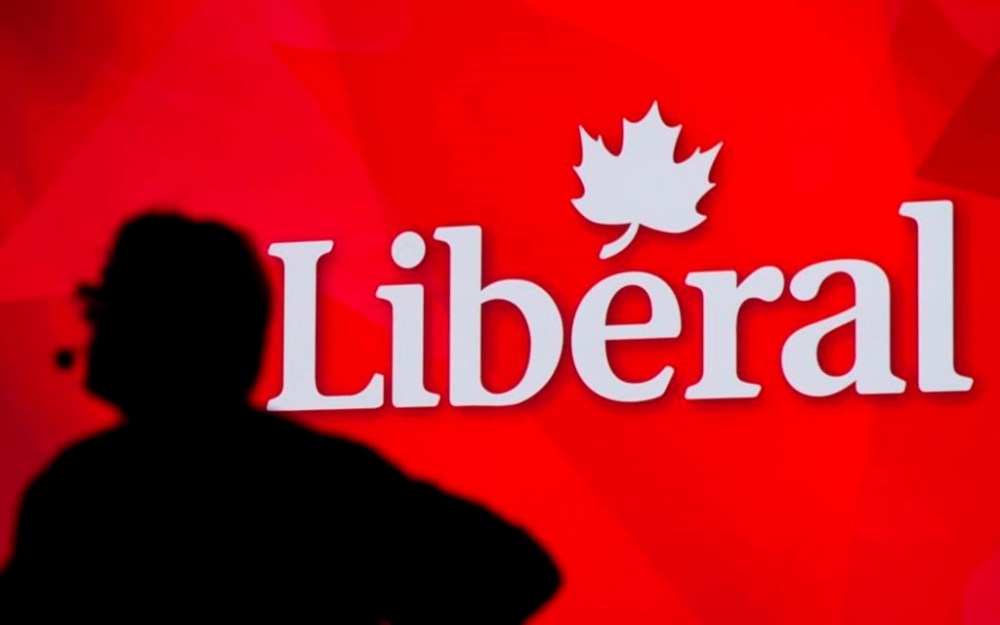 A Liberal Party of Canada logo is shown on a giant screen as a technician looks on during day one of the party's biennial convention in Montreal on February 20, 2014. The federal Liberals say a new party leader to replace Prime Minister Justin Trudeau will be announced on March 9 after a leadership vote. THE CANADIAN PRESS/Graham Hughes