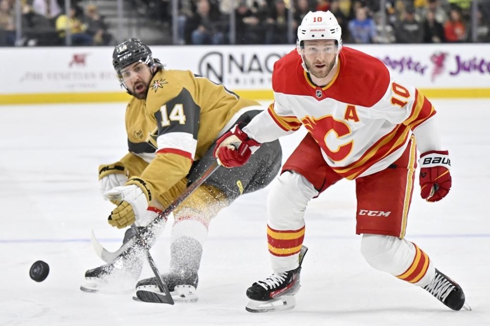 Vegas Golden Knights defenceman Nicolas Hague (14) and Calgary Flames centre Jonathan Huberdeau (10) vie for the puck during the second period of an NHL game on Sunday, Dec. 29, 2024, in Las Vegas. THE CANADIAN PRESS/AP-David Becker
