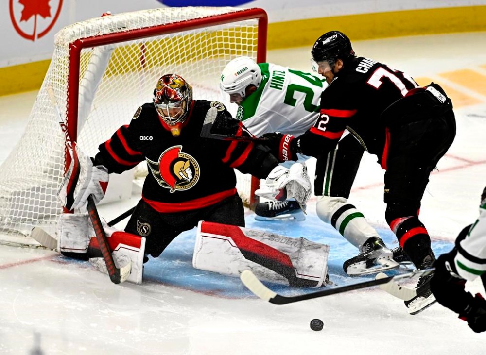 Ottawa Senators goaltender Leevi Merilainen (1) keeps an eye on the rebound after a save as teammate Thomas Chabot (72) checks Dallas Stars' Roope Hintz (24) at the crease during third period NHL hockey action in Ottawa, Sunday, Jan. 12, 2025. THE CANADIAN PRESS/Justin Tang