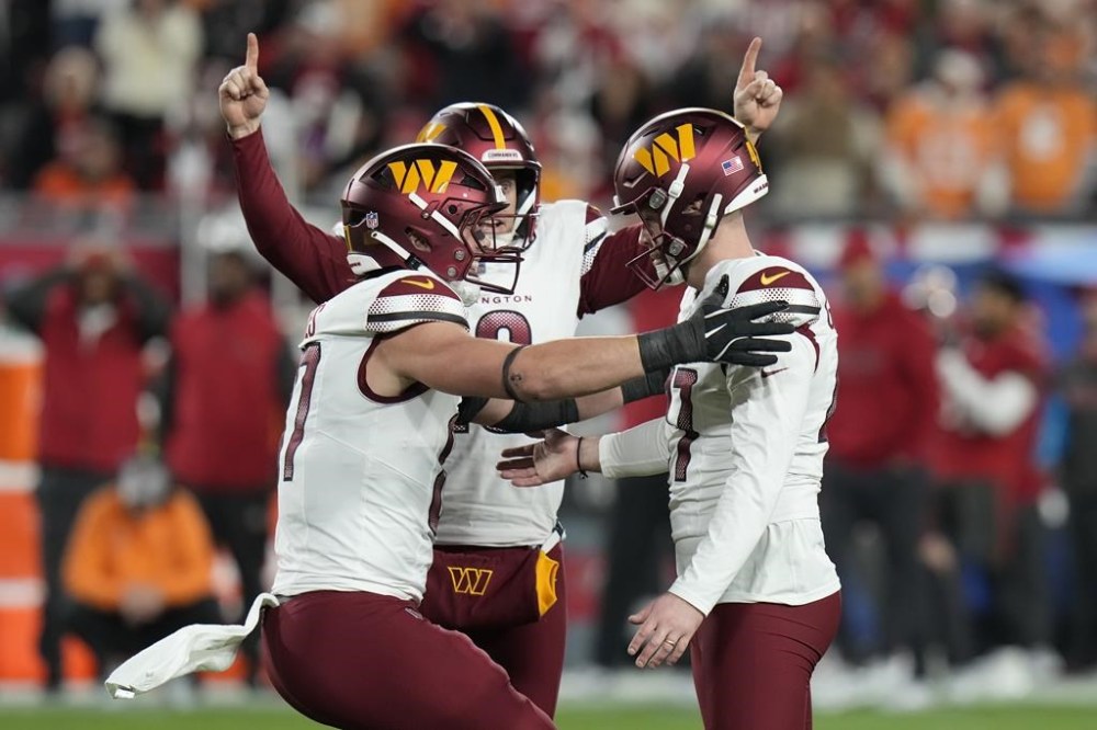 Washington Commanders place kicker Zane Gonzalez, right, is congratulated by teammates after kicking the game winning field goal against the Tampa Bay Buccaneers during the second half of an NFL wild-card playoff football game in Tampa, Fla., Sunday, Jan. 12, 2025. (AP Photo/Chris O'Meara)