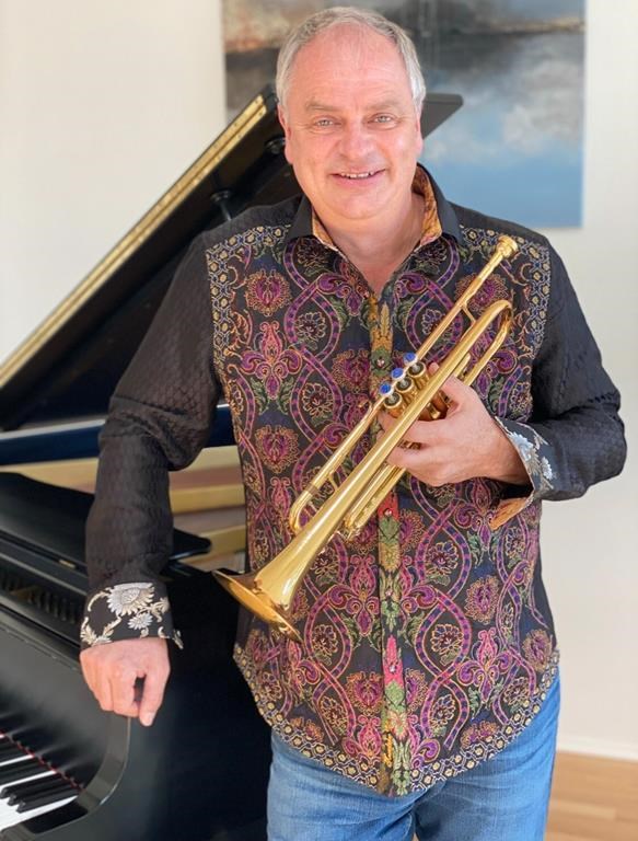 Jens Lindemann, as shown in this undated handout photo, holds a trumpet next to the piano and paintings he lost when his Pacific Palisades home burned down last week. THE CANADIAN PRESS/HO