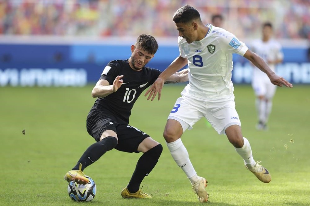 New Zealand's Jay Herdman, left, battles for the ball with Uzbekistan's Bekhruzbek Askarov during a FIFA U-20 World Cup group A soccer match in Santiago Del Estero, Argentina, Tuesday, May 23, 2023. THE CANADIAN PRESS/AP-Nicolas Aguilera