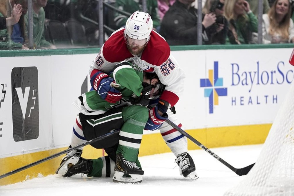 Dallas Stars center Justin Hryckowian, bottom, is held by Montreal Canadiens' David Savard (58) as the two compete for the puck in the first period of an NHL hockey game in Dallas, Thursday, Jan. 16, 2025. (AP Photo/Tony Gutierrez)