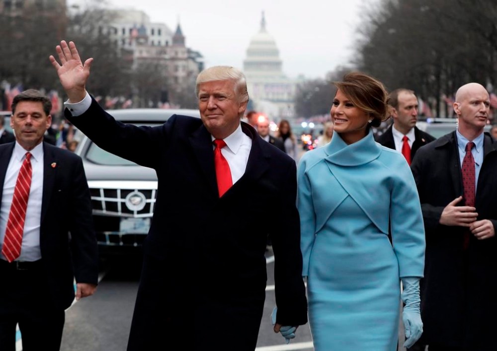 President Donald Trump waves as he walks with first lady Melania Trump during the inauguration parade on Pennsylvania Avenue in Washington, Friday, Jan. 20, 2016. THE CANADIAN PRESS/AP-Evan Vucci
