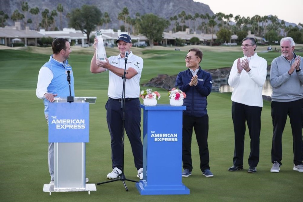 Sepp Straka, second from left, holds the trophy after winning the American Express golf tournament in La Quinta, Calif., Sunday, Jan. 19, 2025. (AP Photo/William Liang)