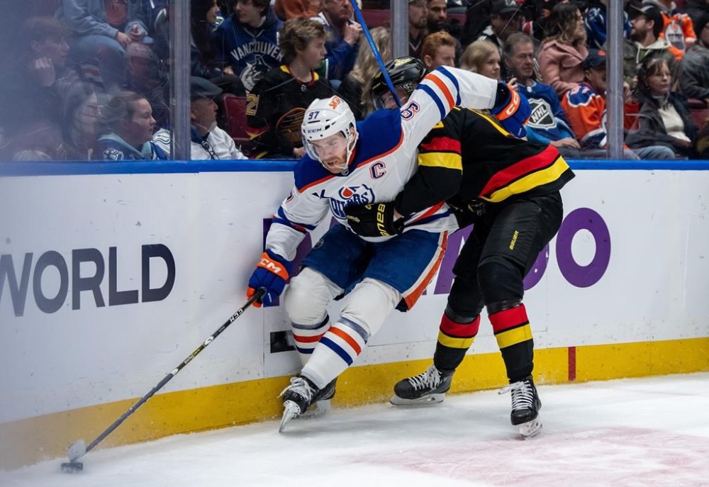 Edmonton Oilers' Connor McDavid (97) and Vancouver Canucks' Elias Pettersson (40) vie for the puck during third period NHL hockey action in Vancouver, B.C., Saturday, Jan. 18, 2025. THE CANADIAN PRESS/Ethan Cairns